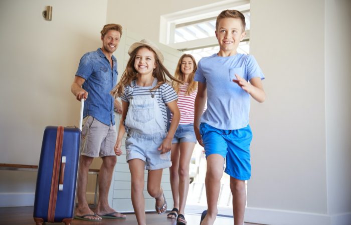 Family Arriving At Summer Vacation Rental