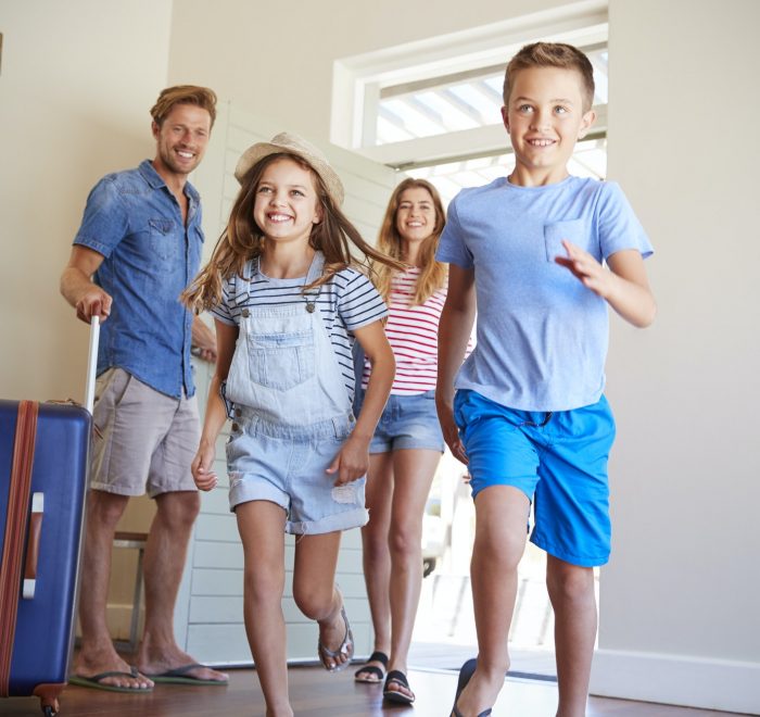 Family Arriving At Summer Vacation Rental